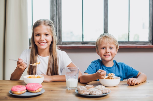 Siblings eating together in the kitchen