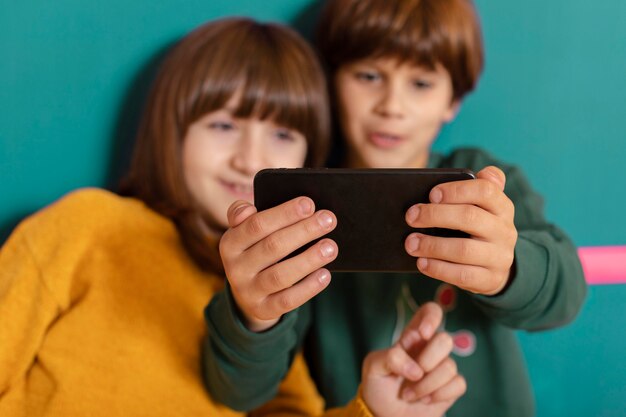 Siblings at home using mobile