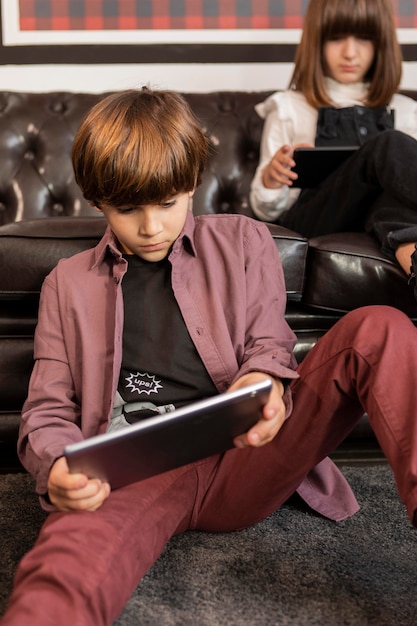 Siblings at home with tablets