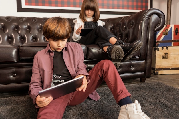 Siblings at home with tablets