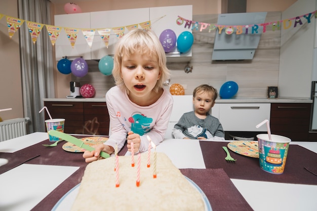 Siblings looking at birthday cake