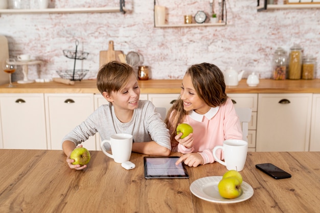 Free photo siblings looking together on their tablet