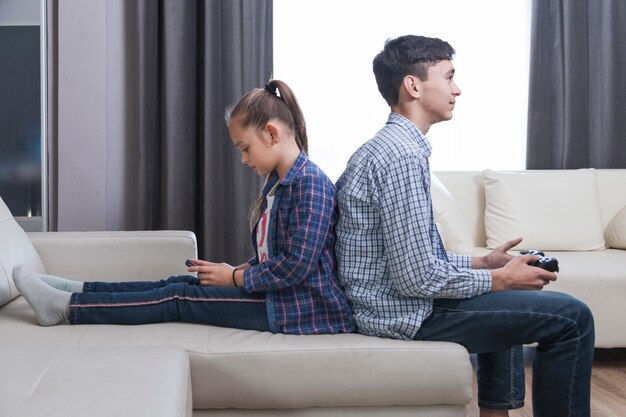 Siblings playing games in living room