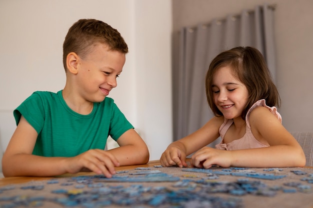 Free photo siblings playing with brain teaser toys