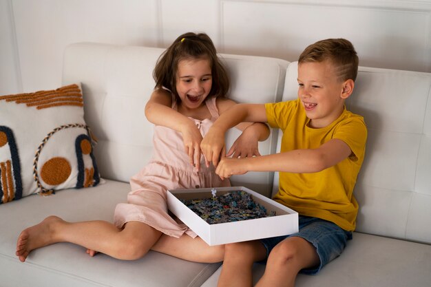 Free photo siblings playing with brain teaser toys