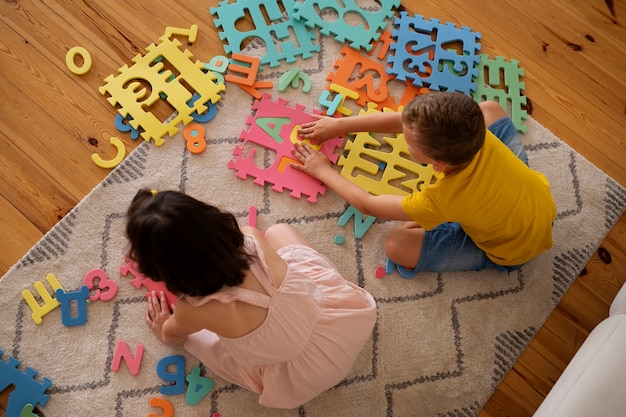 Free photo siblings playing with brain teaser toys