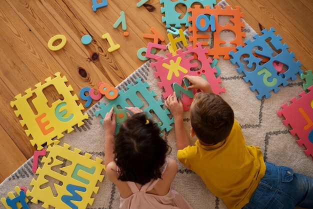 Free photo siblings playing with brain teaser toys