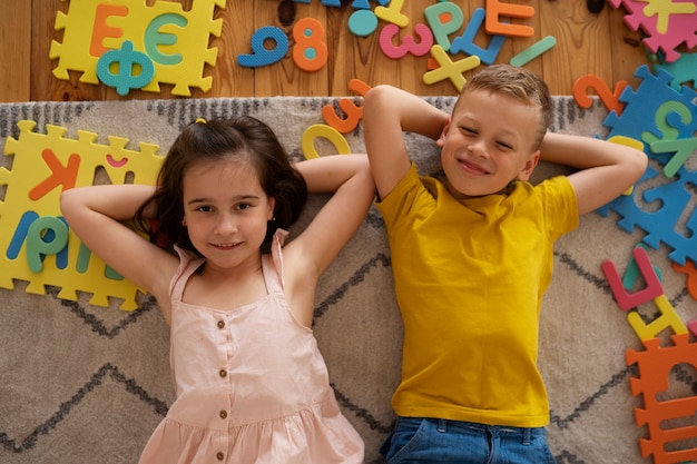 Free photo siblings playing with brain teaser toys