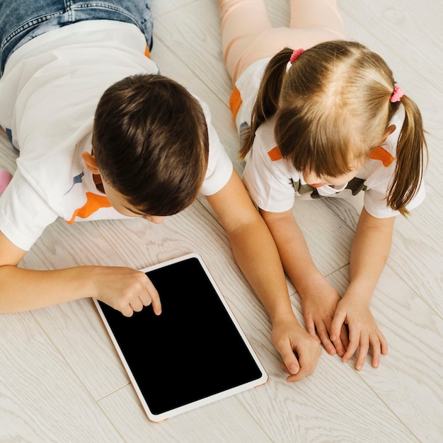 Siblings using a digital tablet high view