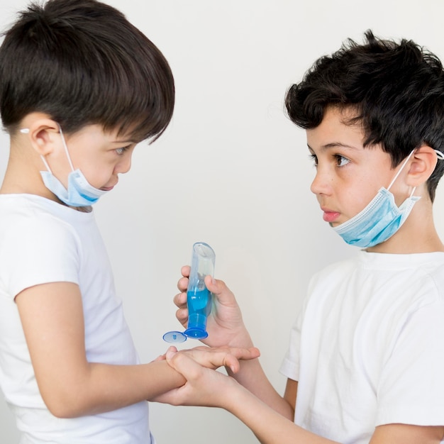 Siblings using hand sanitizer