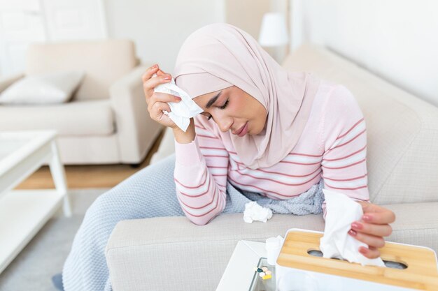 집에서 아픈 날 젊은 아랍 여성은 콧물과 감기에 걸렸습니다. 히잡을 쓴 아름다운 젊은 여성이 감기나 독감에 걸렸습니다.