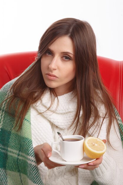 Sick girl posing with a hot drink and a lemon