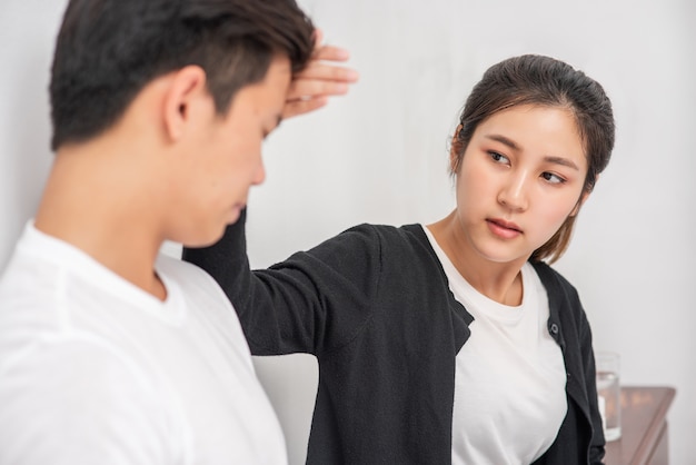 The sick man had a woman look and touch his forehead.