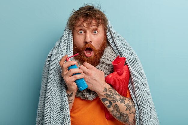 Free photo sick man in warm clothes with spray for sore throat