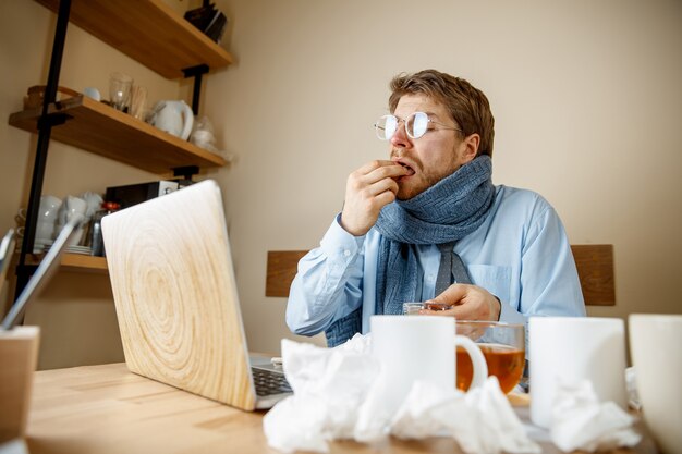 Sick man while working in office, businessman caught cold, seasonal flu.