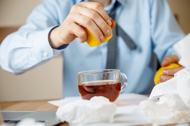 Sick man while working in office, businessman caught cold, seasonal flu.