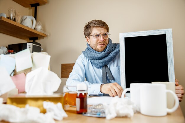 Sick man while working in office, businessman caught cold, seasonal flu.