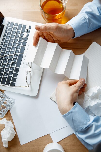 Sick man while working in office, businessman caught cold, seasonal flu.