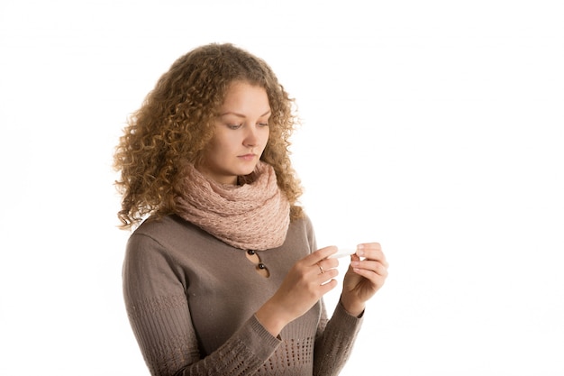 Sick woman checking thermometer