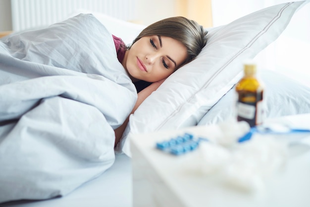 Sick woman lying under the duvet