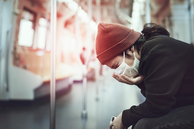 Sick woman in a mask coughing in public during coronavirus pandemic