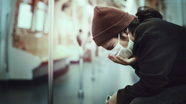 Sick woman in a mask coughing in public during coronavirus pandemic