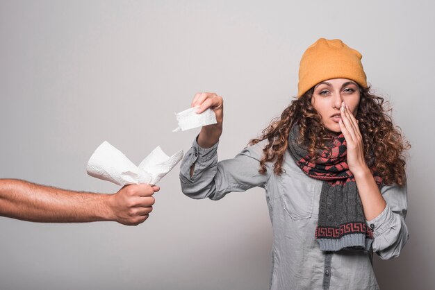 Sick woman suffering from cold taking tissue paper from man's hand