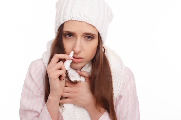 Sick woman using a spray for her nose