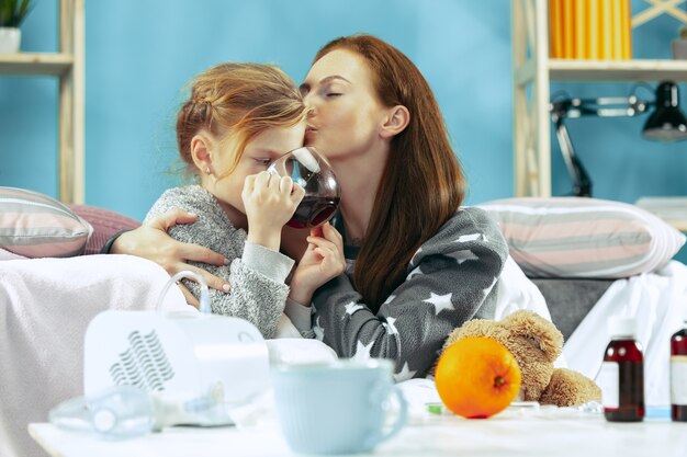 Sick woman with daughter at home. Home Treatment. Medical healthcare.