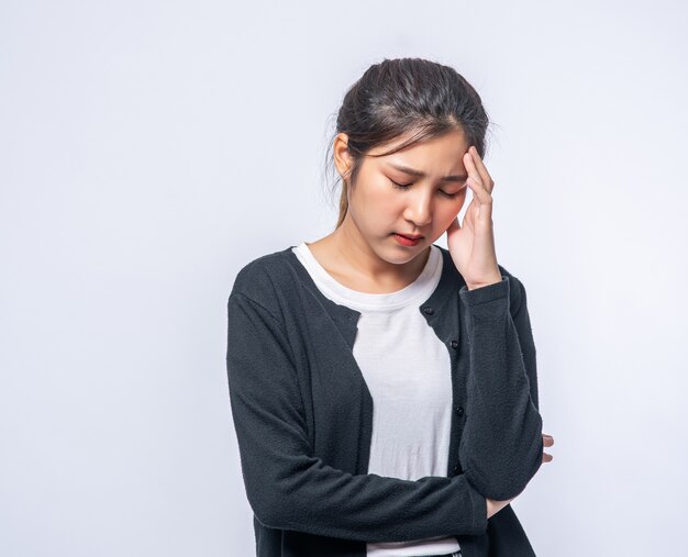 A sick woman with a headache and put her hand on her head