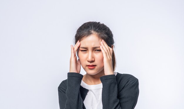 A sick woman with a headache and put her hand on her head