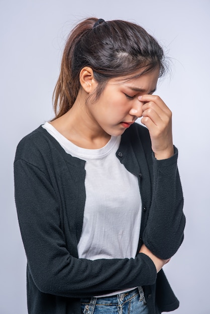 A sick woman with a headache and put her hand on her head