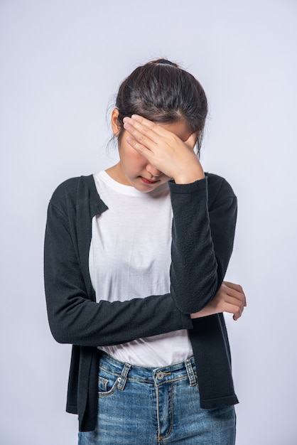 A sick woman with a headache and put her hand on her head