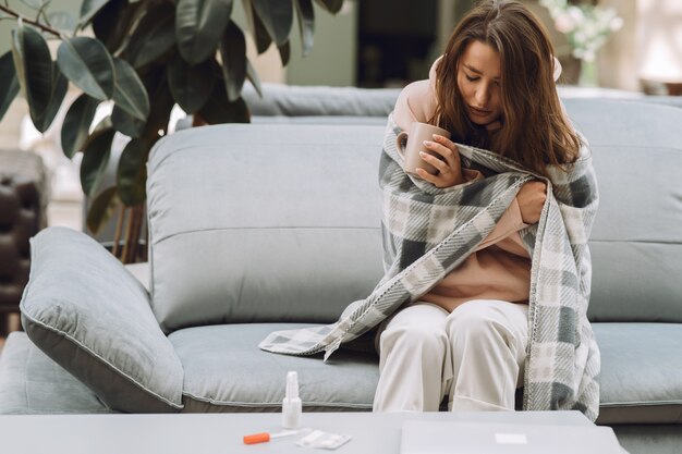 Sick woman with headache sitting at home