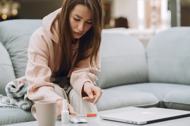 Sick woman with headache sitting at home