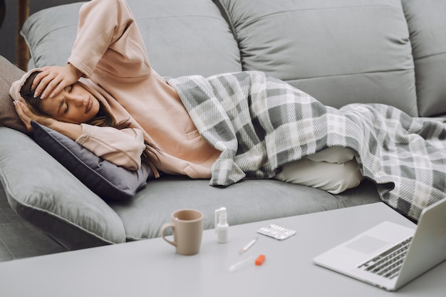 Sick woman with headache sitting at home