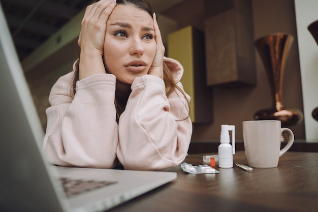 Sick woman with headache sitting at home