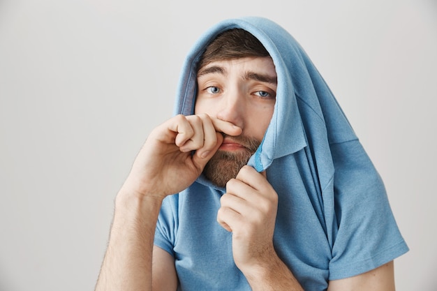 Sick young bearded man posing