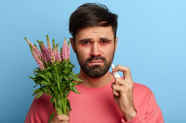 Sick young man suffering from allergy isolated