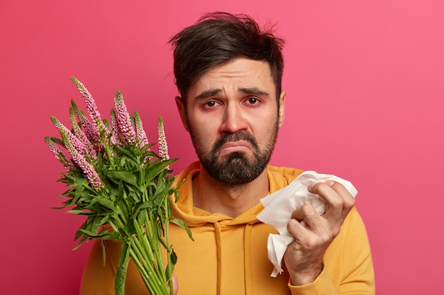 Sick young man suffering from allergy isolated