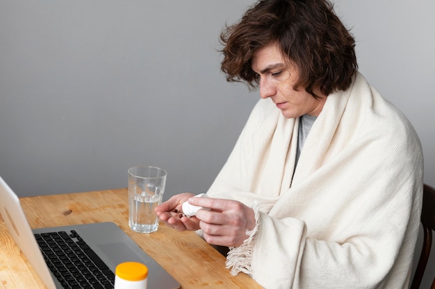 Free photo sick young man talking to his doctor by videocall