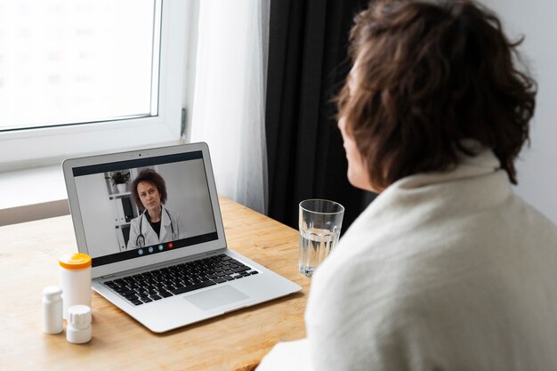 Больной молодой человек разговаривает со своим врачом онлайн