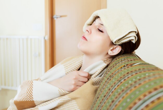 sick young woman uses handkerchief on her head