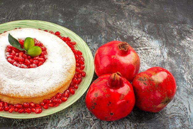 Side close-up view an appetizing cake an appetizing cake with citrus fruits and three pomegranates