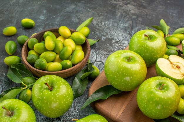 Side close-up view apples the appetizing apples with leaves on the board citrus fruits