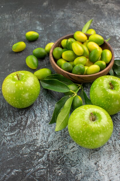 Side close-up view apples apples with leaves citrus fruits in the bowl