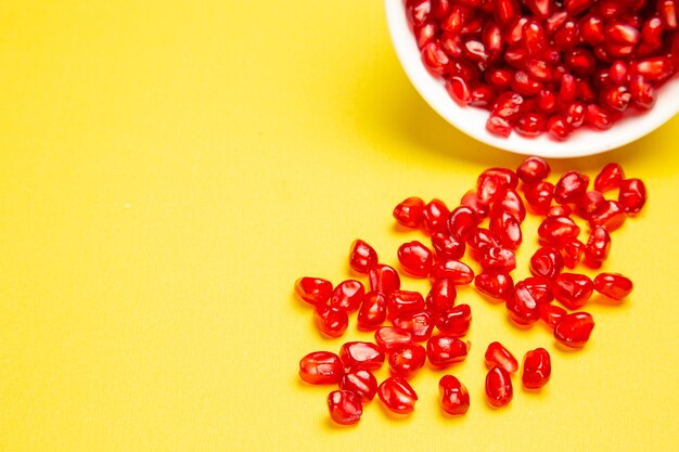 Side close-up view berries the appetizing pomegranate seeds in the bowl