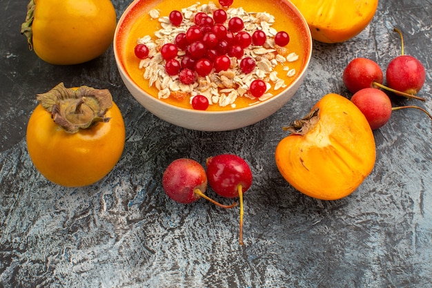 Side close-up view berries cherry red currants in the bowl the appetizing persimmons