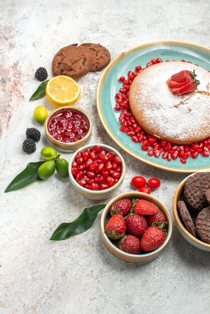 Вид сбоку крупным планом ягоды и печенье торт с клубникой лимонное печенье цитрусовые фрукты