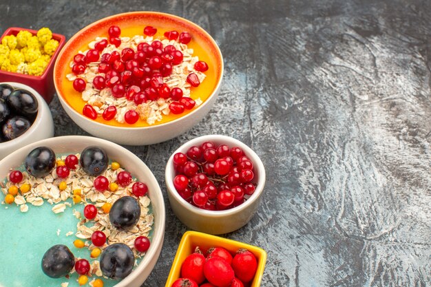 Side close-up view berries oatmeal with pomegranate seeds colorful berries yellow candies